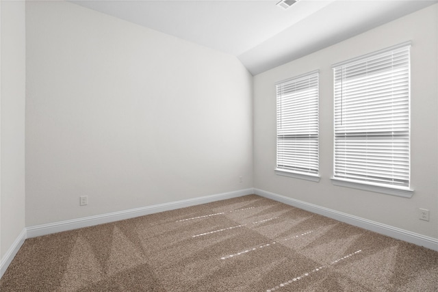 spare room with vaulted ceiling and carpet floors