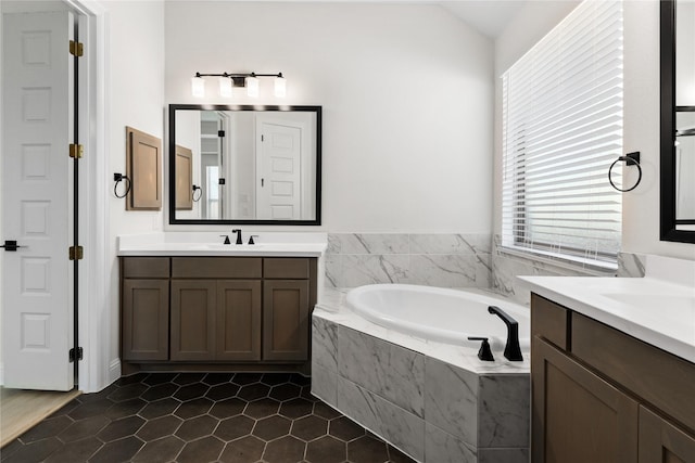 bathroom featuring tile patterned flooring, vanity, lofted ceiling, and a relaxing tiled tub