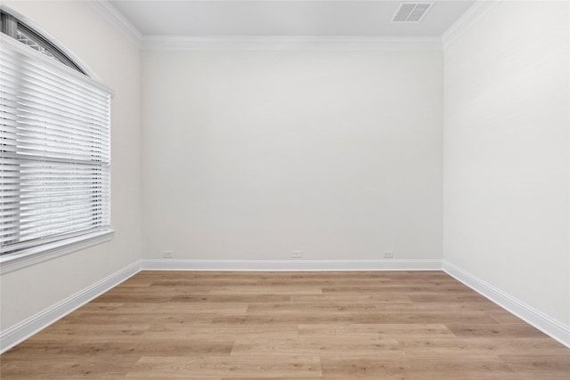 empty room with ornamental molding and light wood-type flooring