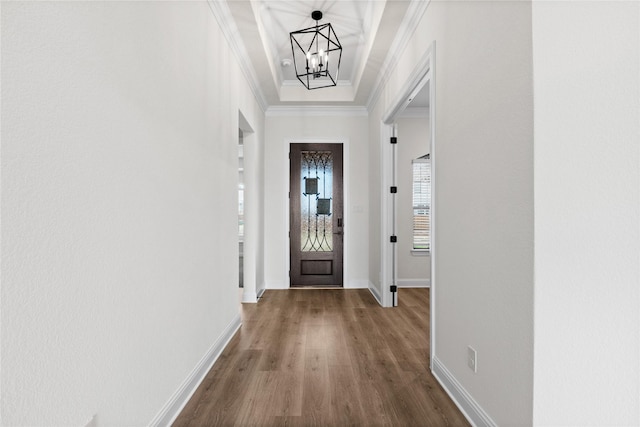 entryway featuring crown molding, wood-type flooring, and a chandelier