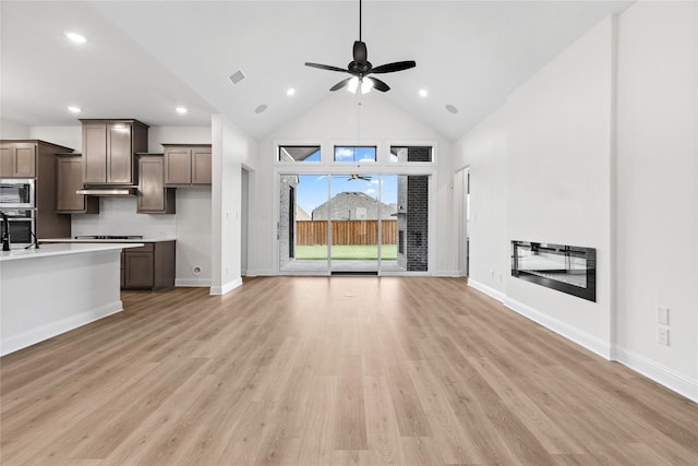 unfurnished living room featuring ceiling fan, high vaulted ceiling, and light hardwood / wood-style flooring