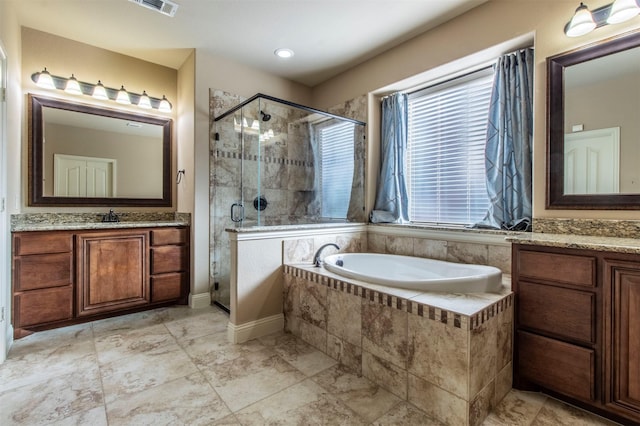 bathroom with a garden tub, a sink, two vanities, and a shower stall