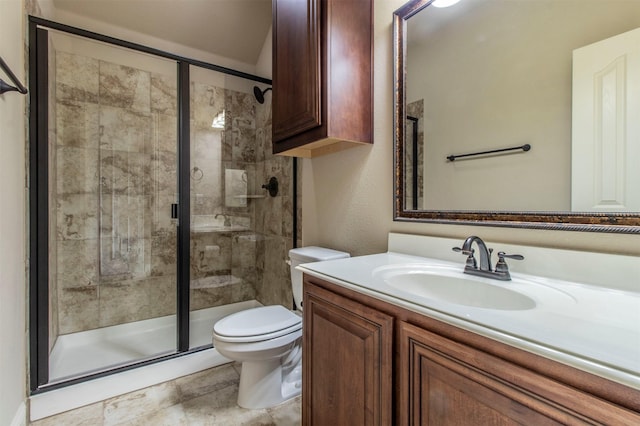 bathroom featuring vanity, a shower stall, and toilet