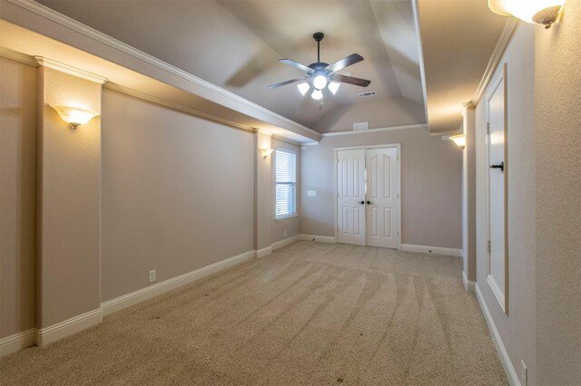 interior space featuring ceiling fan, light colored carpet, ornamental molding, and vaulted ceiling