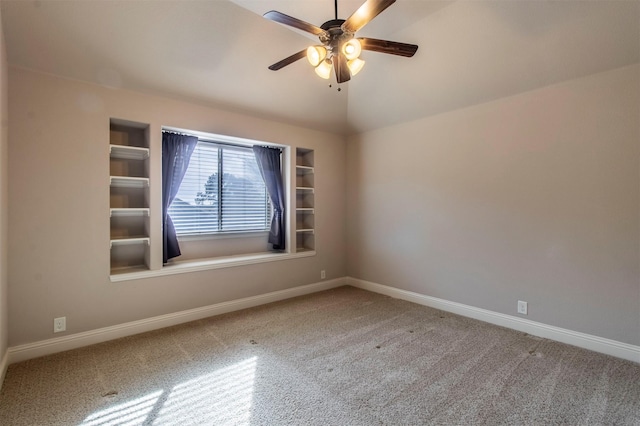 empty room with ceiling fan, lofted ceiling, built in features, and carpet floors