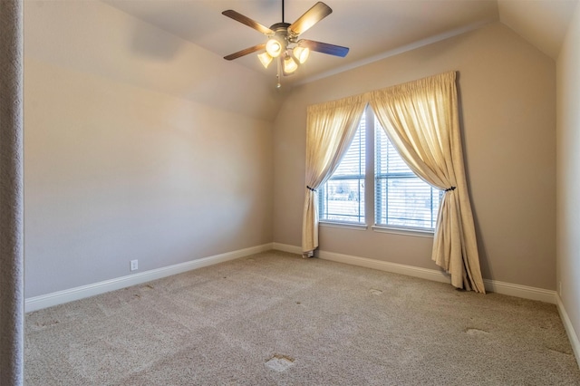 spare room featuring vaulted ceiling, ceiling fan, carpet, and baseboards