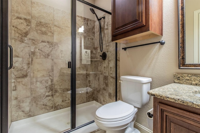 bathroom featuring toilet, vanity, and an enclosed shower