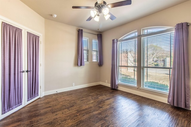 empty room featuring wood finished floors, a ceiling fan, and baseboards