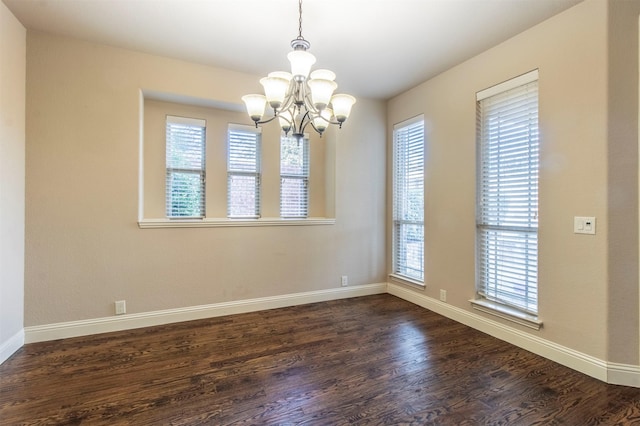 unfurnished room with a notable chandelier, baseboards, and dark wood-style flooring