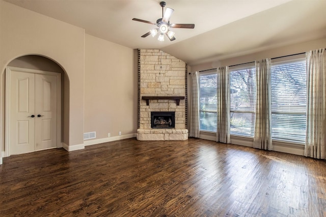 unfurnished living room with ceiling fan, vaulted ceiling, a fireplace, and dark hardwood / wood-style floors