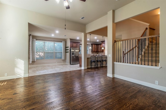 unfurnished living room featuring light wood-type flooring and ceiling fan