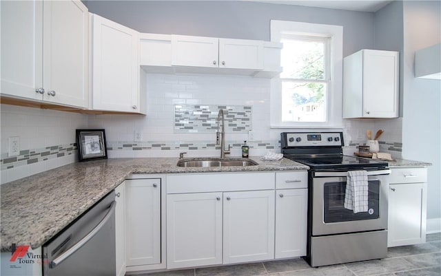 kitchen featuring white cabinets, sink, appliances with stainless steel finishes, tasteful backsplash, and light stone counters