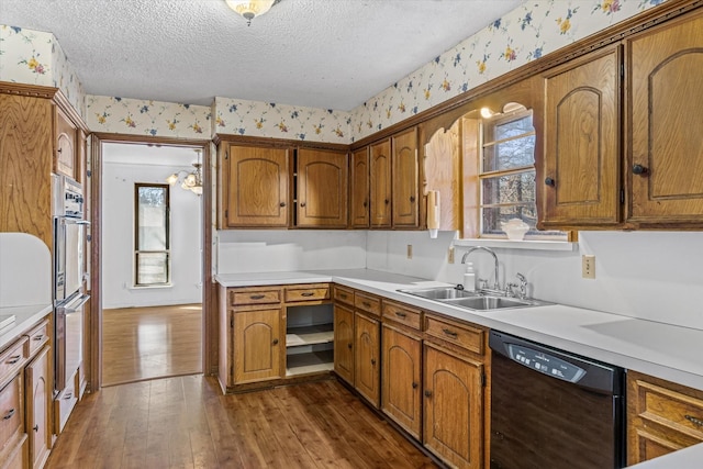 kitchen with dark hardwood / wood-style floors, black dishwasher, sink, and a textured ceiling