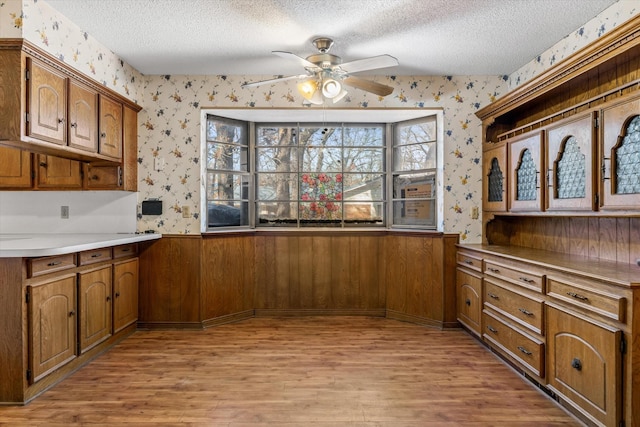 kitchen featuring ceiling fan, light wood-type flooring, and a textured ceiling