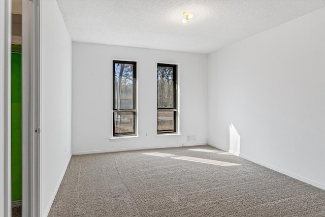 carpeted spare room featuring a textured ceiling