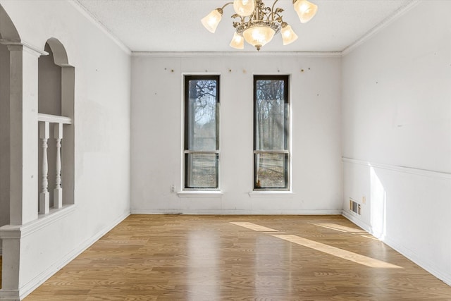 unfurnished room featuring crown molding, hardwood / wood-style flooring, plenty of natural light, and a textured ceiling