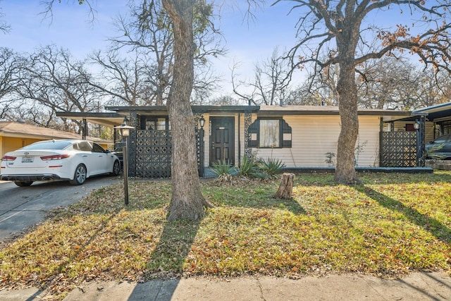 single story home featuring a carport and a front yard