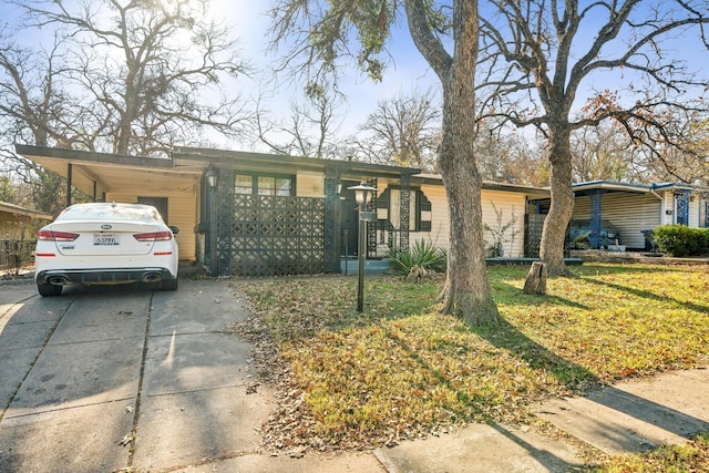 single story home featuring a front yard and a carport