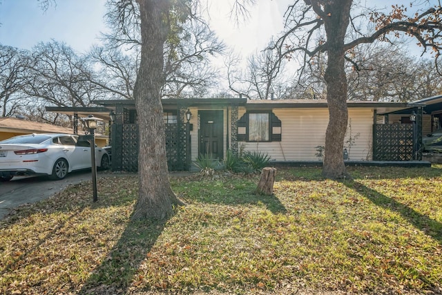 ranch-style home with a front lawn and a carport