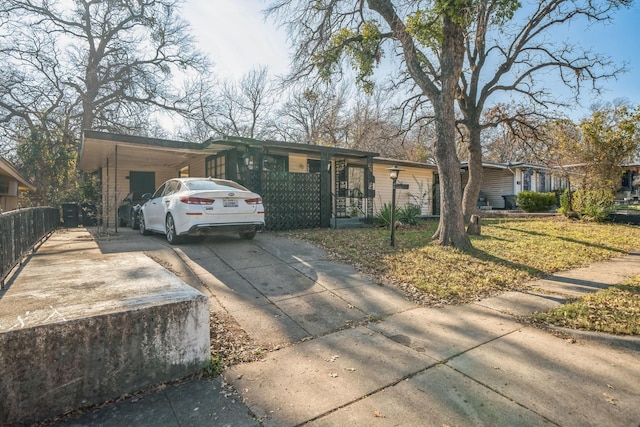 ranch-style house featuring a front yard and a carport