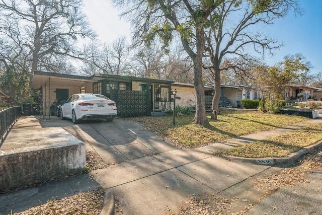 ranch-style house featuring a carport and a front yard