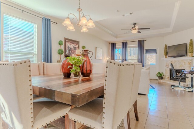 living room featuring a fireplace, ornamental molding, a raised ceiling, and a ceiling fan