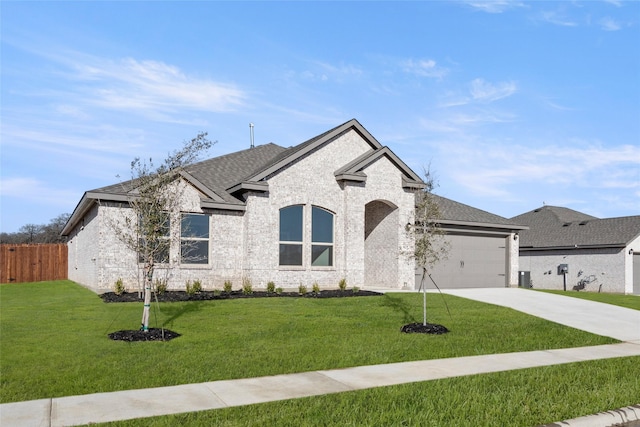 french country home with a garage, a front lawn, driveway, and a shingled roof