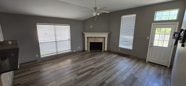 unfurnished living room with hardwood / wood-style flooring, vaulted ceiling, ceiling fan, and a fireplace