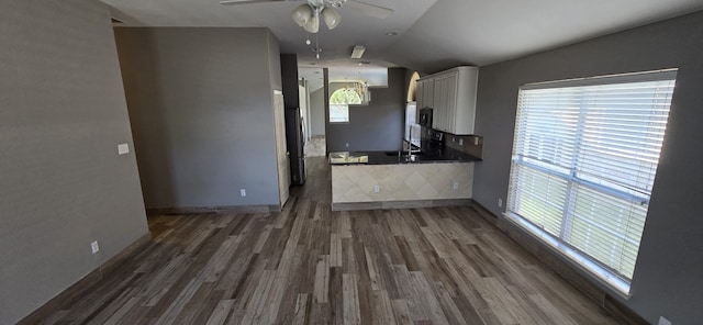 kitchen featuring white cabinets, vaulted ceiling, dark hardwood / wood-style floors, ceiling fan, and stainless steel refrigerator