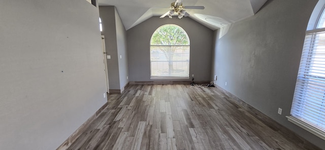 unfurnished dining area with dark wood-type flooring, ceiling fan, and vaulted ceiling