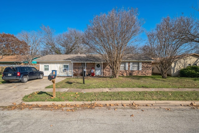 ranch-style house featuring driveway and a front lawn