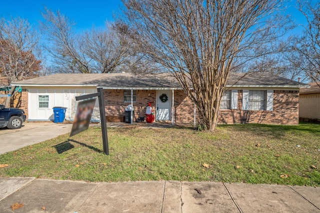 ranch-style home with a front lawn, board and batten siding, and brick siding