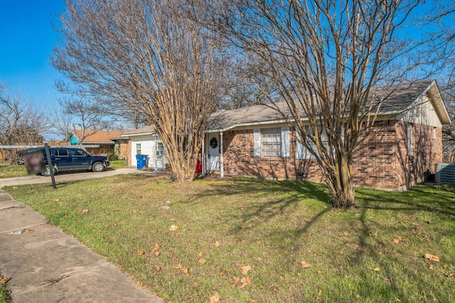 ranch-style home featuring concrete driveway, brick siding, and a front yard