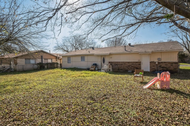 back of property featuring a lawn