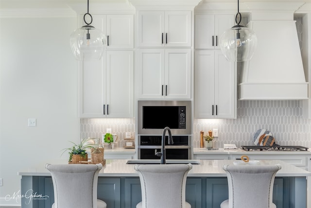 kitchen featuring a breakfast bar, decorative backsplash, and white cabinetry