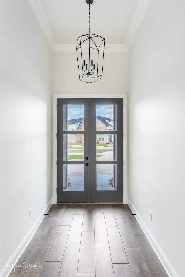 doorway to outside featuring crown molding, dark hardwood / wood-style flooring, a chandelier, and french doors