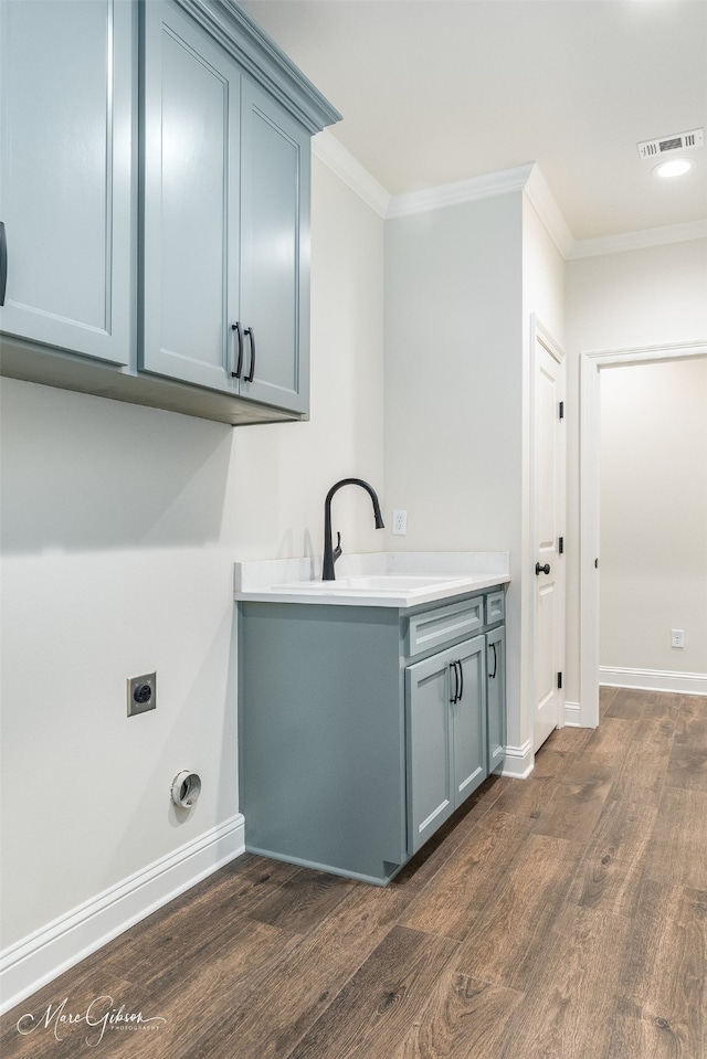 laundry room featuring sink, cabinets, ornamental molding, dark wood-type flooring, and hookup for an electric dryer