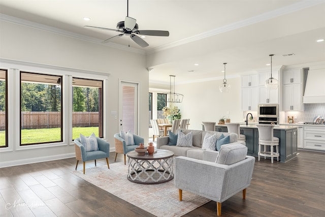 living room featuring ceiling fan, ornamental molding, dark hardwood / wood-style flooring, and sink