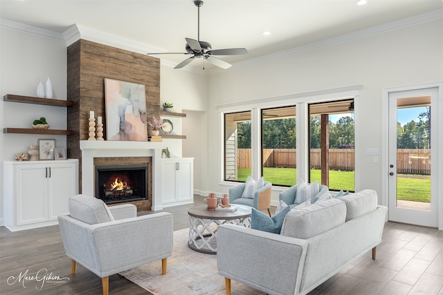 living room with hardwood / wood-style floors, ornamental molding, and ceiling fan