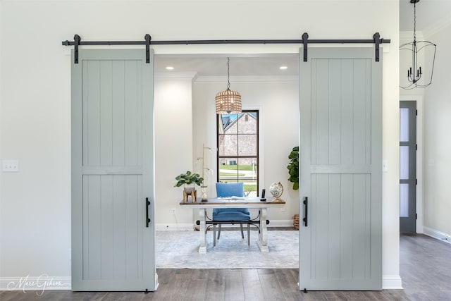 interior space with a barn door, wood-type flooring, and crown molding