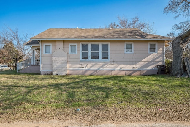 rear view of property with a yard