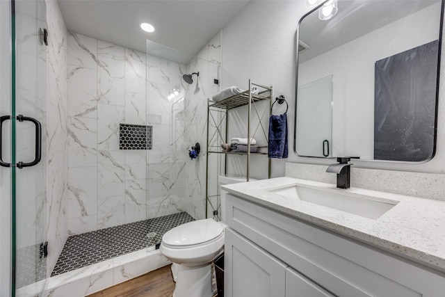 bathroom with vanity, toilet, and a shower with shower door