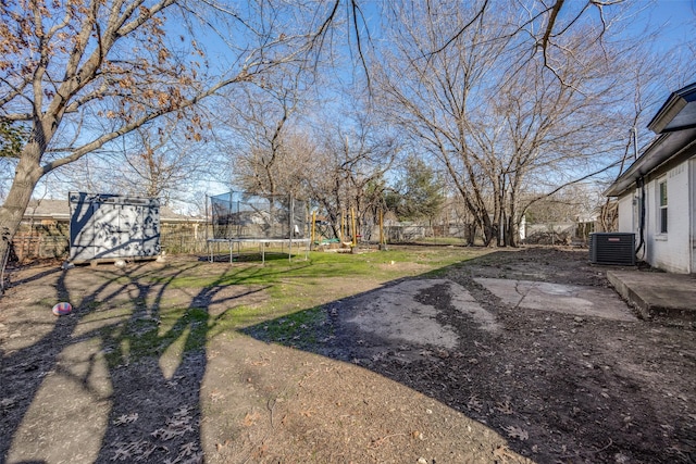 view of yard featuring cooling unit, a shed, and a trampoline