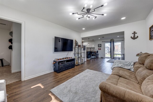 living room with dark wood-type flooring and a notable chandelier