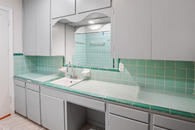 bathroom featuring tile patterned flooring, vanity, tasteful backsplash, and walk in shower