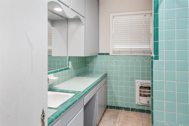 bathroom with tile patterned floors, heating unit, vanity, and tile walls