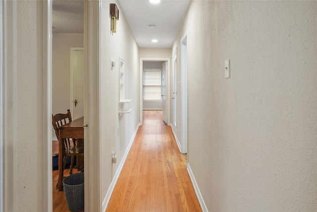 hallway with light hardwood / wood-style flooring