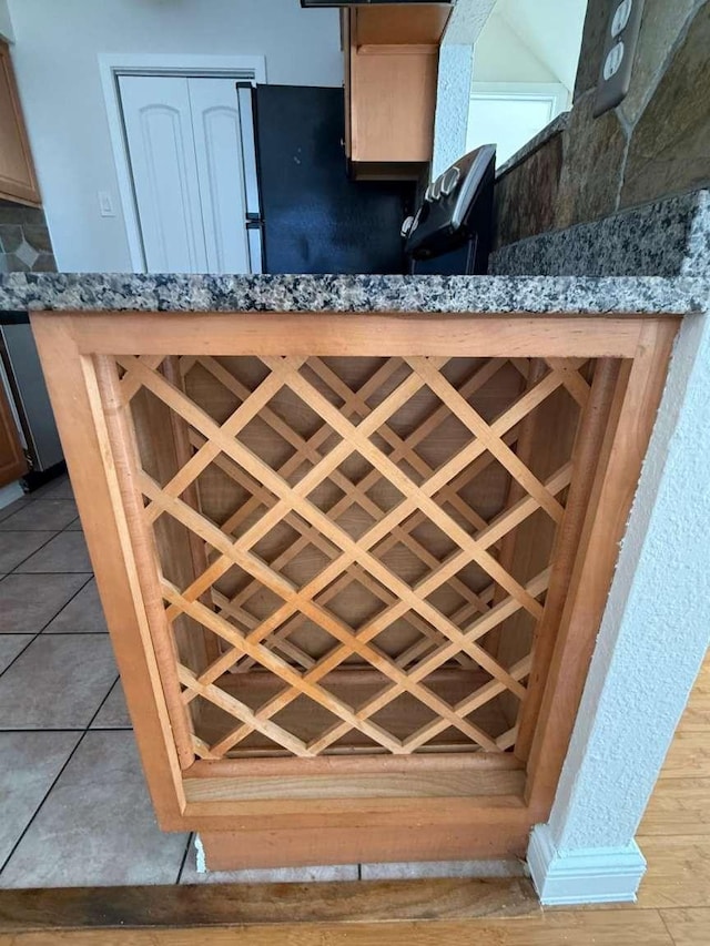 details featuring bar area, decorative backsplash, and refrigerator