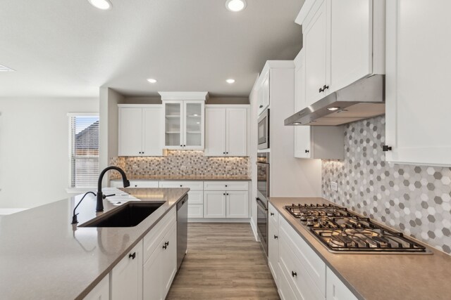 kitchen with white cabinets, light hardwood / wood-style floors, sink, and stainless steel appliances