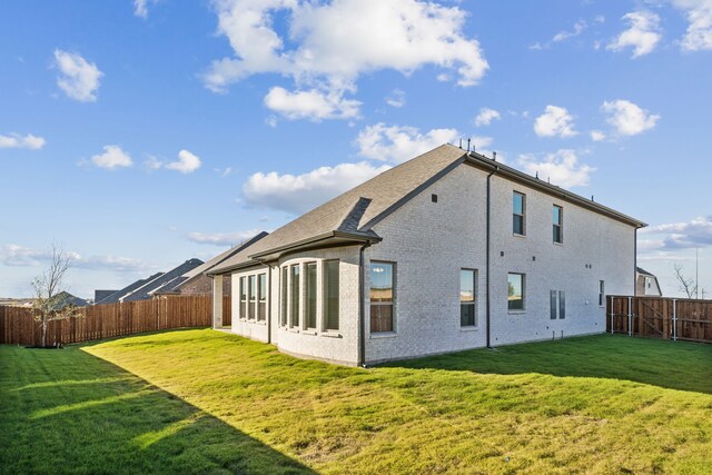 back of house with a lawn